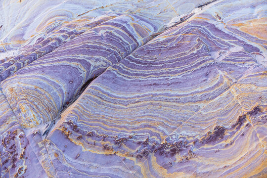 Colourful purple patterns in eroded slate deposits in a creek bed