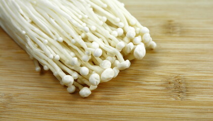 Enoki mushrooms on the cutting board.