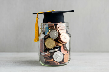 Coin filled jar topped with graduation cap celebrates education savings