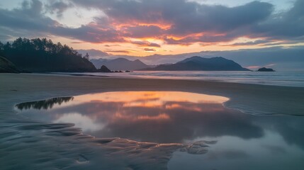 Obraz premium Sunset sky reflecting on a shallow tide pool near the shoreline.