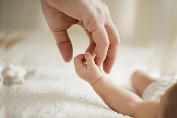 Adult hand holding babys highlights care and connection