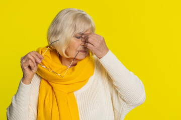Exhausted tired senior old woman takes off glasses feels eyes pain, being overwork burnout from...