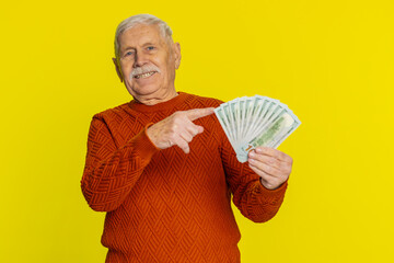 Rich happy senior old man pointing on money dollar cash banknotes bills fan, success business...