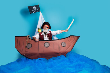 Photo of confident pirate swimming in the sea wooden ship theater performance isolated on blue color background