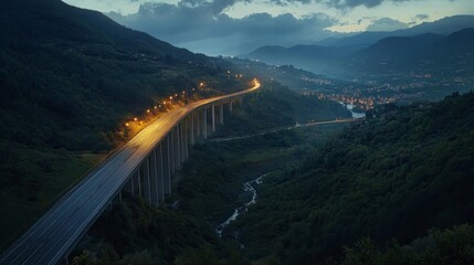 An overhead image of a freeway bridge that connects towns at nightfall, spanning a valley with green hills and forests, as part of infrastructural expansion. 