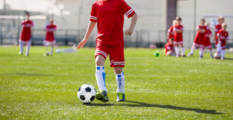 Young Soccer Players Running With Ball In Training Drill. Kids in Soccer Red Uniforms. Soccer...