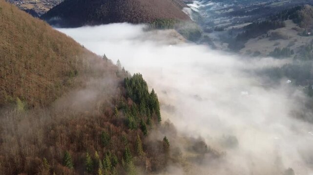Aerial View of a Mountain Village in the Carpathians, Morning Fog Covers Houses, Fields, and Forests in the Valley