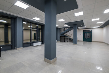 Obraz premium panorama view in empty modern hall with columns, doors and panoramic windows at night