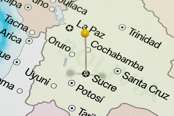 Close up to a Sucre city with a white pin needle into Bolivia country political map 
