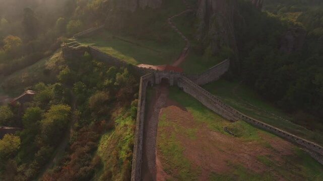 Aerial view of belogradchik fortress at sunrise surrounded by majestic rock formations and tranquil valley, belogradchik, bulgaria.