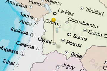 Macro photo of a yellow pin needle into uyuni city of Bolivia political map