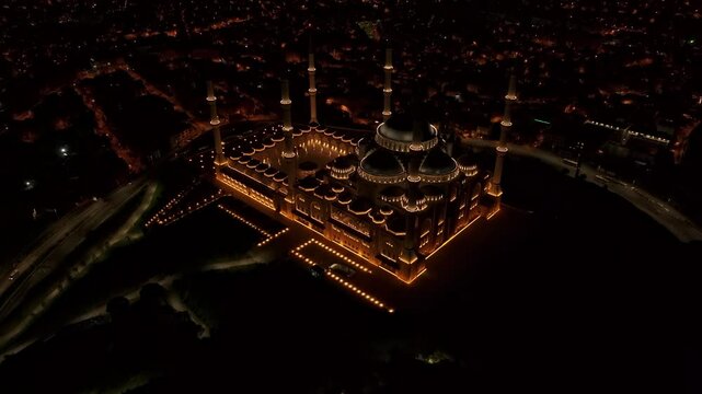 Aerial view of grand camlica mosque illuminated at night with city lights, Istanbul, Turkey.