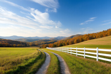 scenic dirt road winds through vibrant autumn landscape, bordered by white fence. rolling hills and colorful trees create picturesque view under bright blue sky