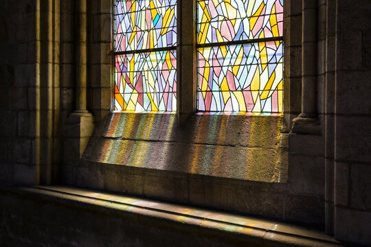 Saint-Malo, France - June 22, 2018: Partial view of a stained-glass window by french painter Jean Le Moal, illuminated by sunlight in the southern side aisle of Saint-Vincent cathedral.