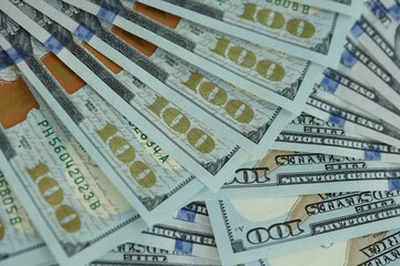 Many hundred dollar bills new banknotes in big pile under the natural light