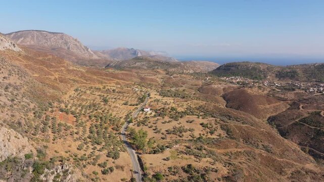 Aerial view of scenic winding road through beautiful hills and arid mountains in Milas, Mugla, Turkey.