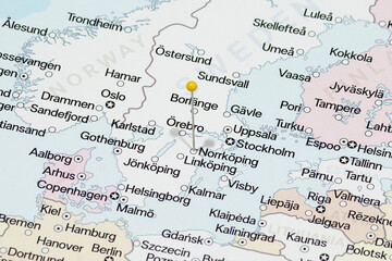 Macro photo of a yellow pin needle into Norrkoping city of Sweden political map 