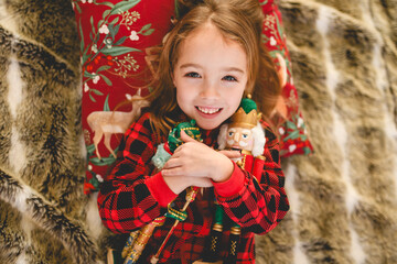 A Beauty child who holding a nutcracker in front of fireplace