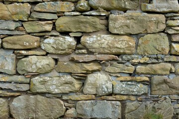 Obraz premium Photo of Old grey and brown stone wall. Background texture for backdrops or mapping