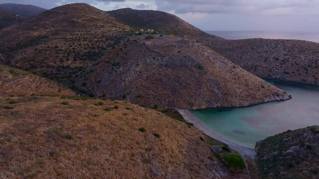 Aerial view of Vathi Beach at sunrise with serene Mediterranean Sea and rugged hills, Lagia, Peloponnese, Greece.