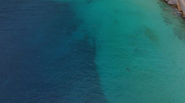 Aerial view of beautiful boats sailing in the turquoise Mediterranean Sea along the scenic coastline, Limeni, Greece.