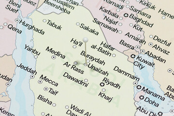 Macro photo of a white pin needle into Unaizah city of Saudi Arabia political map 