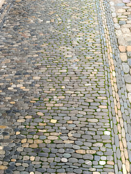 buntes rundes Kleinpflaster als Stra&szlig;enbelag mit Abgrenzung in L&auml;ngsformen