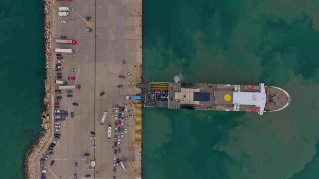 Kyllini, Greece - 01 December 2024: Aerial view of the bustling ferry dock with moored vessels and blue water, Kyllini, Greece.