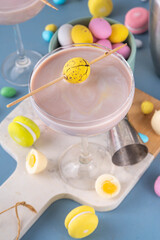 Easter chocolate sweet martini alcohol cocktail, cream and vodka alcohol beverage with a lot of chocolate mini eggs on kitchen table, copy space