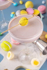 Easter chocolate sweet martini alcohol cocktail, cream and vodka alcohol beverage with a lot of chocolate mini eggs on kitchen table, copy space