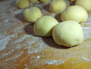 Several balls of dough are prepared for making donuts. Ukrainian dish. Cooking theme.
