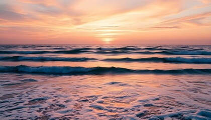 Obraz premium A still ocean at sunset with waves softly rolling and a colorful sky