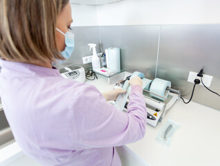 Nurse preparing sterilization pouches for autoclave in dental clinic