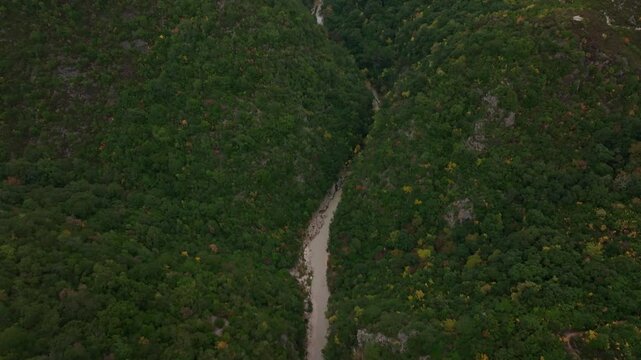 Aerial view of the beautiful Acheron Springs canyon with a serene river flowing through a lush green valley, Epirus, Greece.