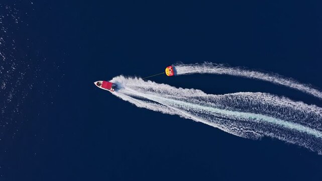 Aerial view of parasailing boats on clear blue water with waves, Fethiye, Turkey.