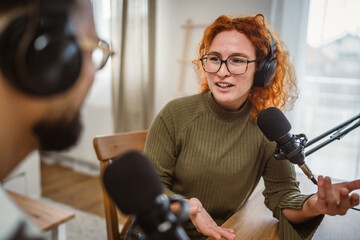 two radio hosts smile and enjoy while record podcast in studio