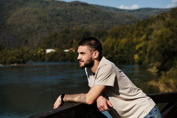 Young man travels to the Balkan countries in early autumn. The Drina River flows on the border of Serbia and Bosnia and Herzegovina, in the Tara National Park.
