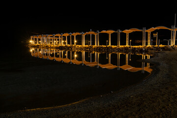 Lighted walk way out into the water at night at the Dead Sea in Israel

