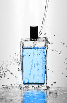 glass bottle with perfume in water splashes