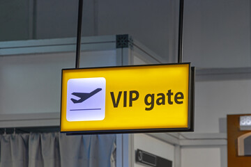 Illuminated Vip Gate Yellow Sign Hanging from Ceiling at Airport