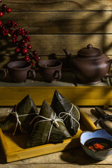 Rice dumpling zongzi in steaming basket with tea set - Traditional sweet Chinese food on a plate to eat for Dragon Boat Duanwu Festival celebration in rustic tone