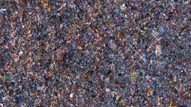 Aerial view of a messy garbage landfill with overflowing waste and seagulls, Tirana, Albania.