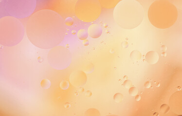 Beautiful cosmetic background. Pink yellow orange abstract oil bubbles or face serum background.
