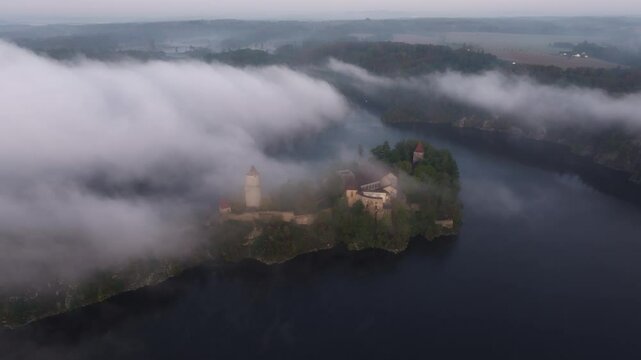 Aerial view of Zvikov Castle and the Moldau river at sunrise surrounded by fog, Zvikovske Podhradi, Czech Republic.
