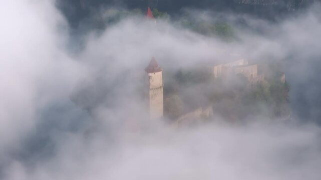 Aerial view of Zvikov Castle surrounded by fog and the Moldau river at sunrise, Zvikovske Podhradi, Czech Republic.