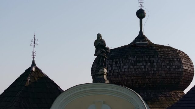 Aerial view of ornate Kostel sv. Jana Krtitele a Panny Marie Karmelske church with a scenic roof and statue, Smolotely, Czech Republic.