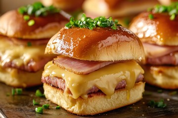Delicious mini ham and cheese sliders on toasted brioche buns, garnished with fresh chives, perfect for a party snack or appetizer.