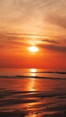 Obraz premium Magnificent sunset over the sea, casting warm colors across the sky and reflecting on the calm waters.