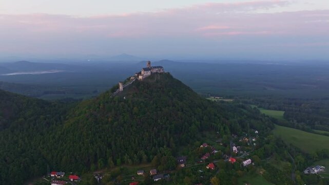 Aerial view of bezdez castle at sunset surrounded by tranquil forest and picturesque village, bezdez, czech republic.