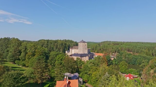 Aerial view of kost castle surrounded by lush forest and quaint village, Dobsin, Czech Republic.
